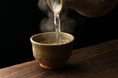 Warm sake poured from a ceramic bottle - designed to keep the liquid warm for the longest amount of time.