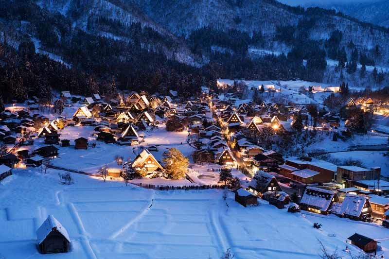 Traditional triangular wooden roofs covered in snow at night