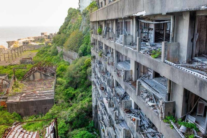 Abandoned and derelict building overlooking an overgrown island and the ocean