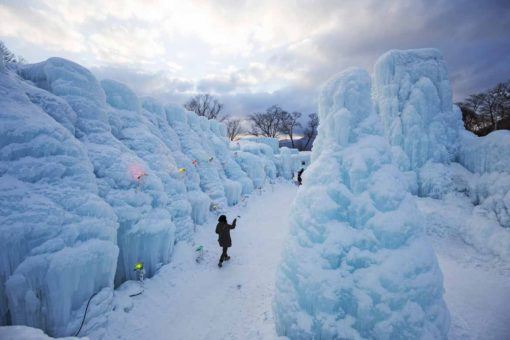 Lone person walking amidst ice structures